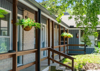 the front of a building with a porch and trees