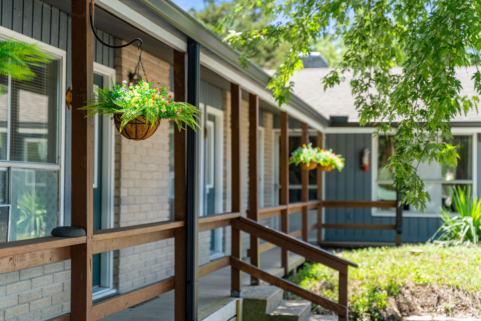 the front of a building with a porch and trees
