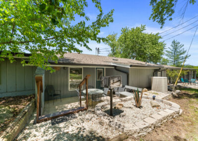 a small house with a yard and trees in front of it