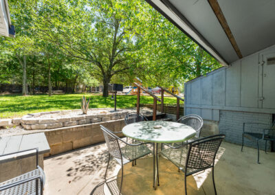 a covered patio with a table and chairs