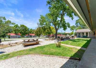 a patio with a picnic table and picnic benches