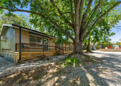 a mobile home sits under a large tree