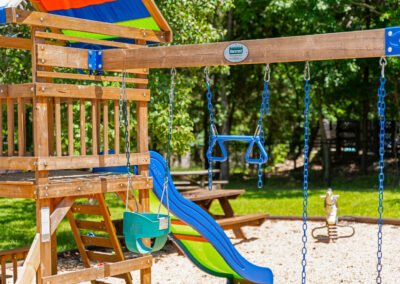a wooden swing set with a slide and swings