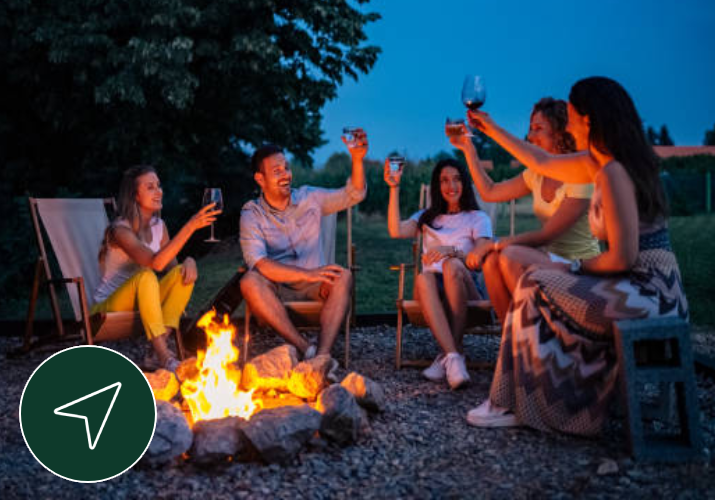 a group of people sitting around a campfire toasting